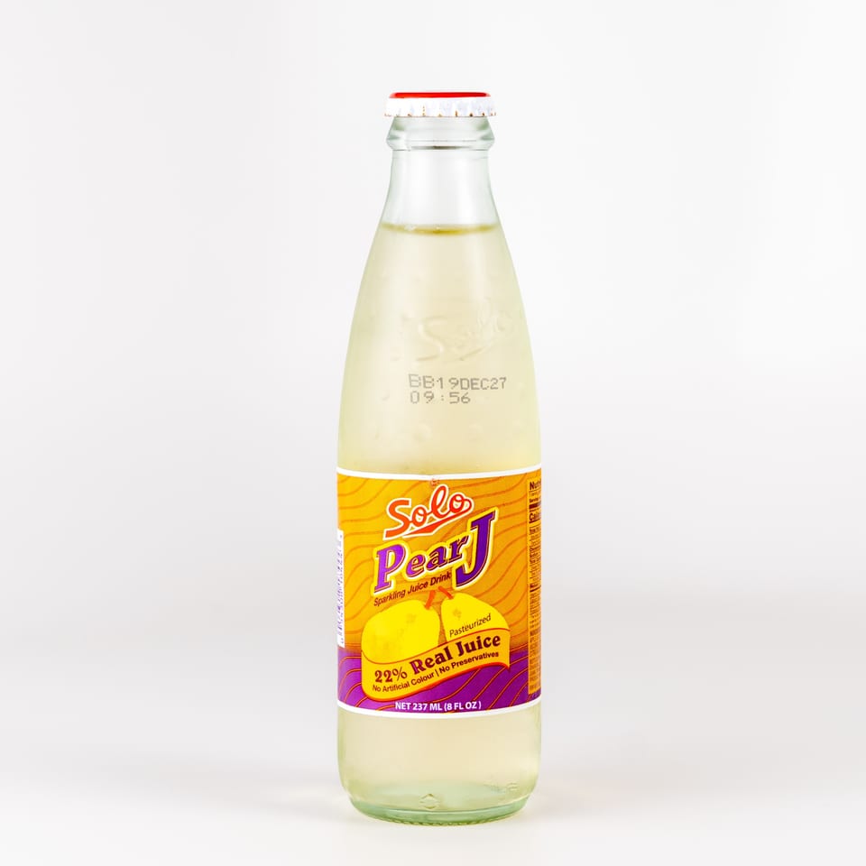 A glass bottle of Solo Pear J sparkling juice drink with a yellow and purple label.